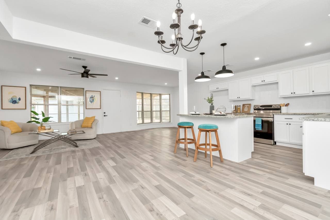 White kitchen renovation with granite island and new flooring
