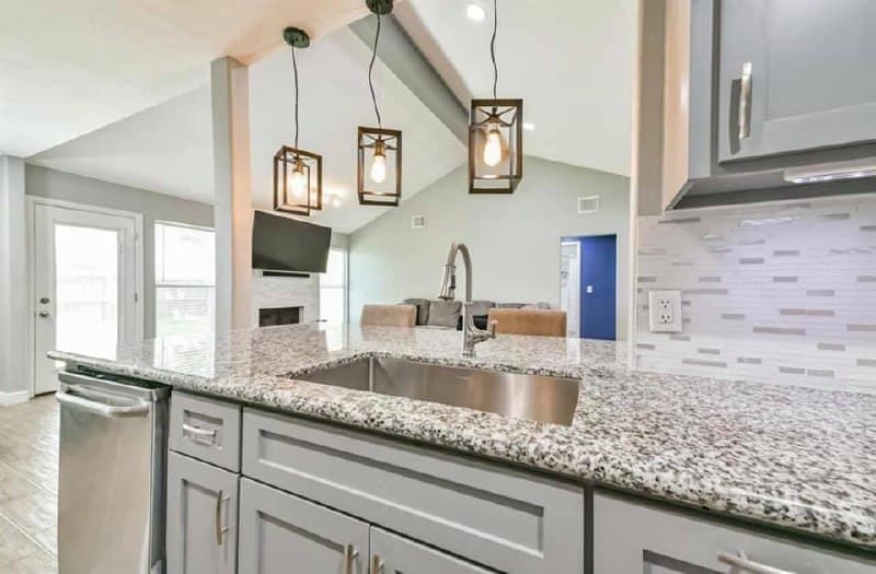 Kitchen island with granite top and industrial pendant lighting