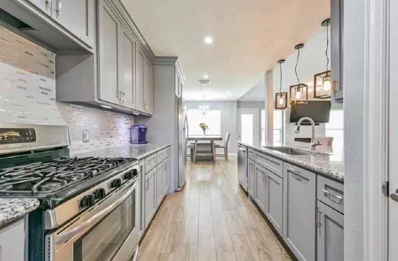 Full kitchen renovation with gray shaker cabinets and granite island